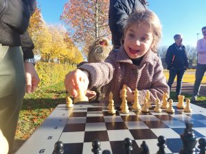 Kleindochter van Frank bij schaaktafel, met op de achtergrond Franks broer